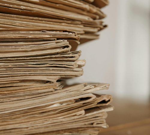 Close-up of vintage paper stacks on a wooden table, evoking a classic office setting.